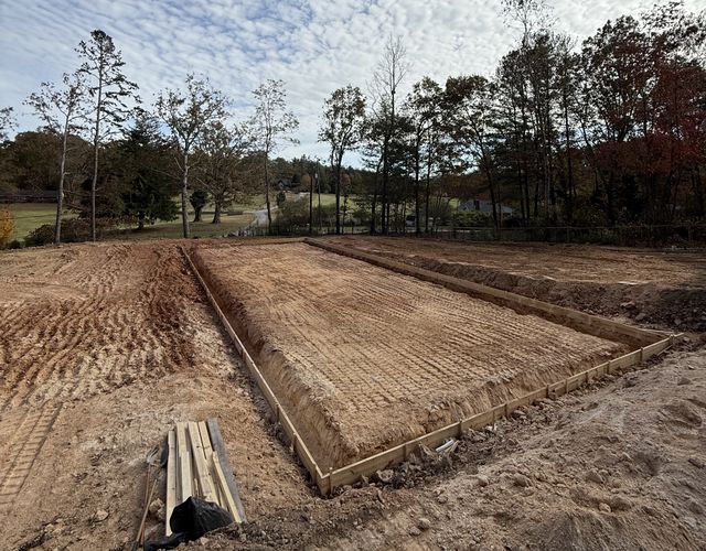 Excavated foundation footer trenches with wooden forms on a cleared, graded building lot near Canton, North Carolina